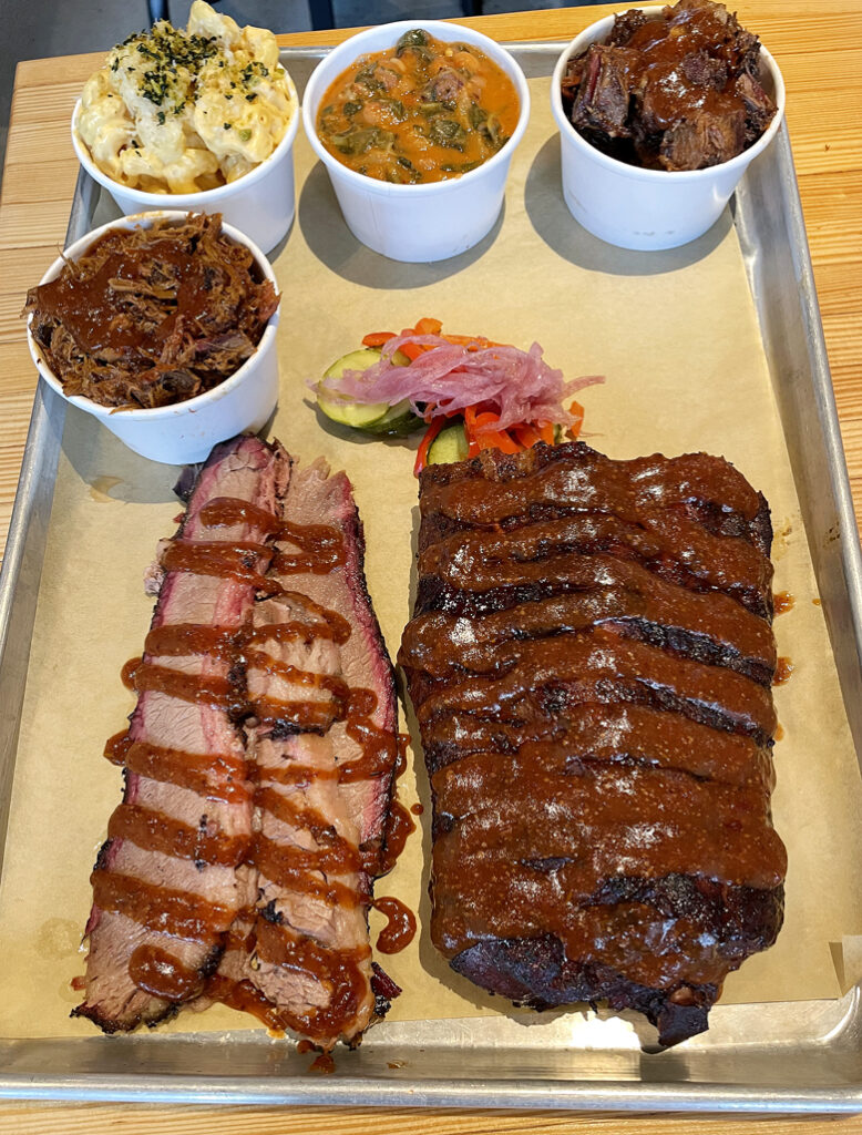 (Clockwise from top): beans & greens; burnt ends, baby back ribs, brisket, pulled pork, and mac & cheese.